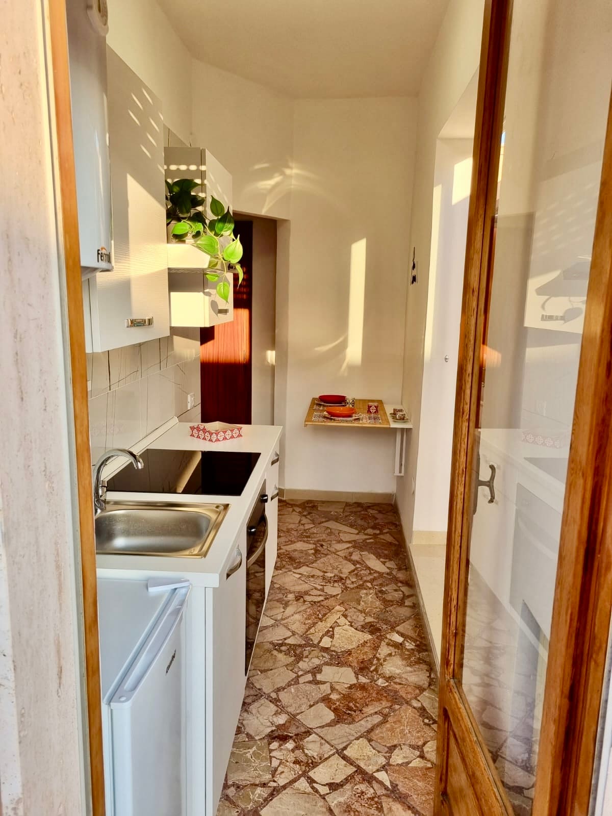 Cucina con piano a induzione, lavello e frigorifero
