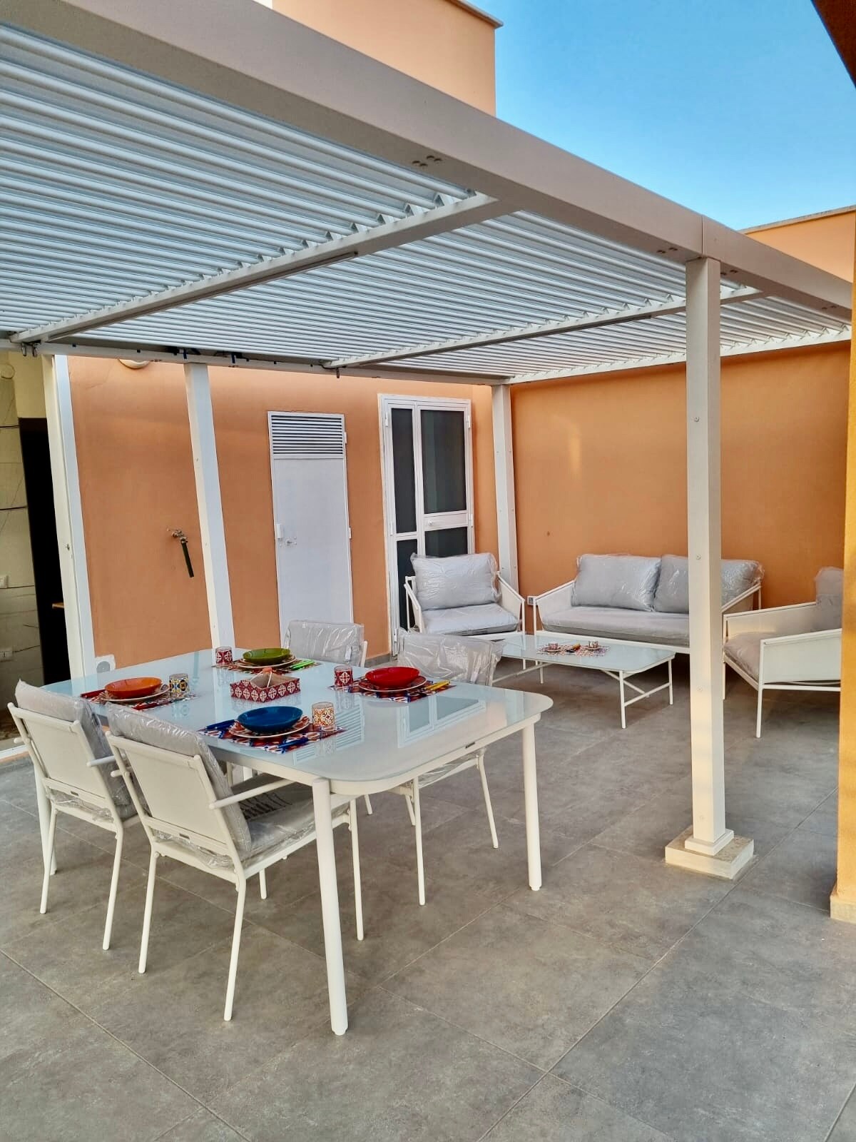 Area relax della terrazza con divani e poltrone bianche